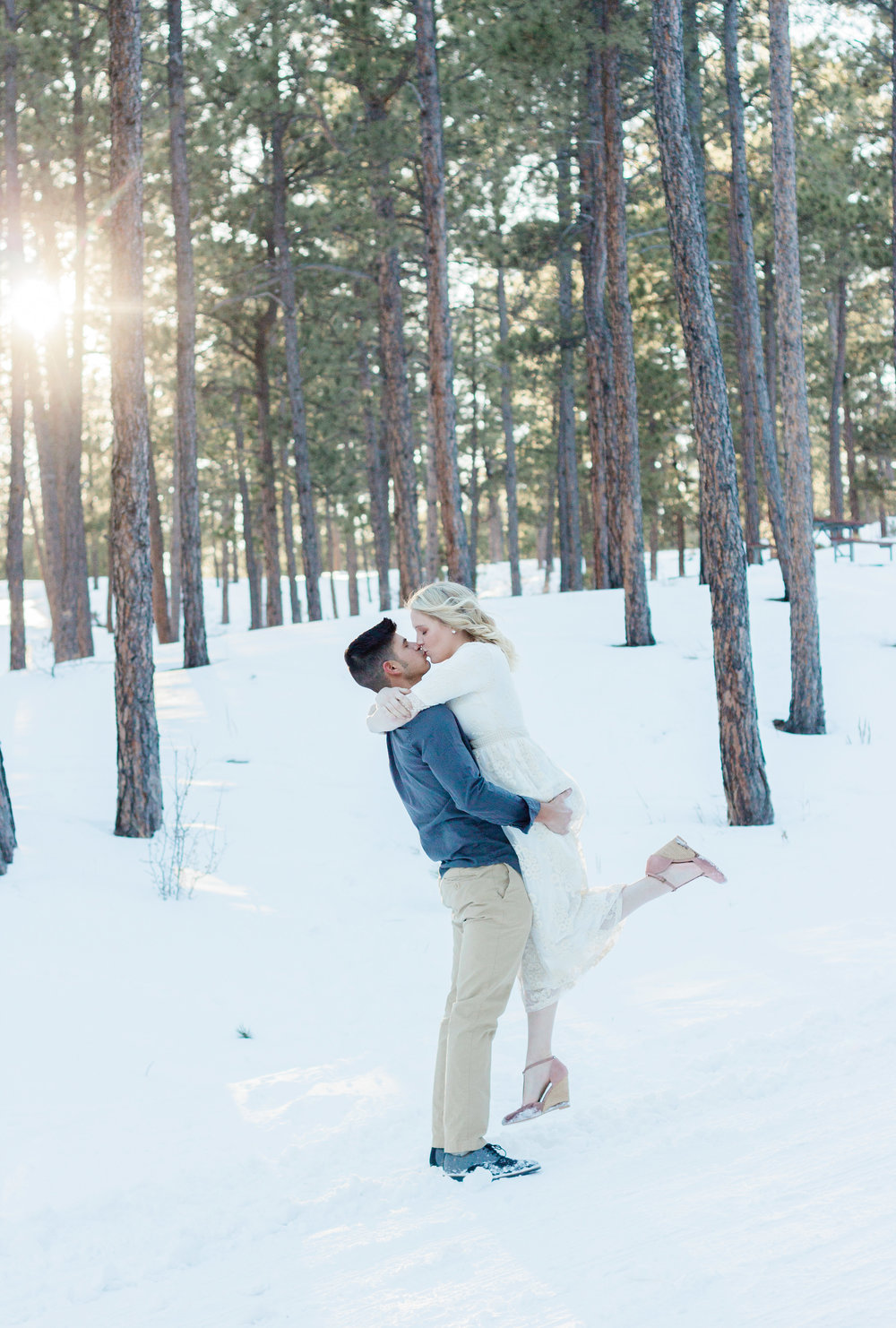 couple kissing during black forest engagement session