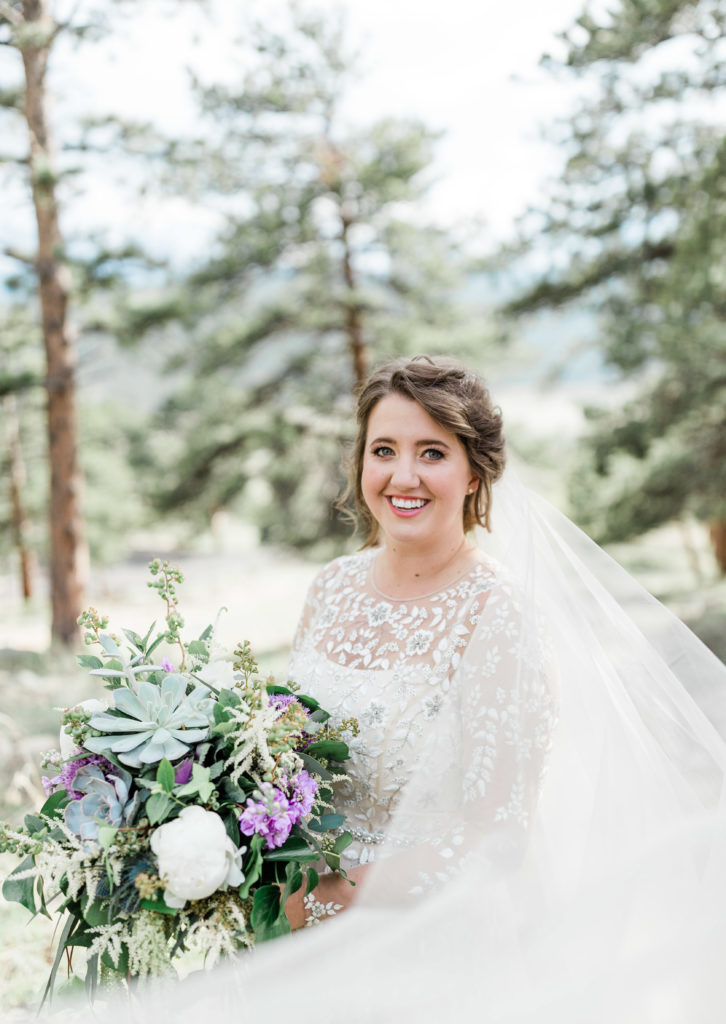 Bride smiling with her succulent and blueberry bride bouquet