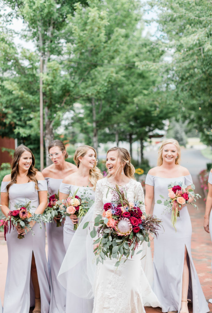bride and bridesmaids smiling in courtyard at crooked willow farms