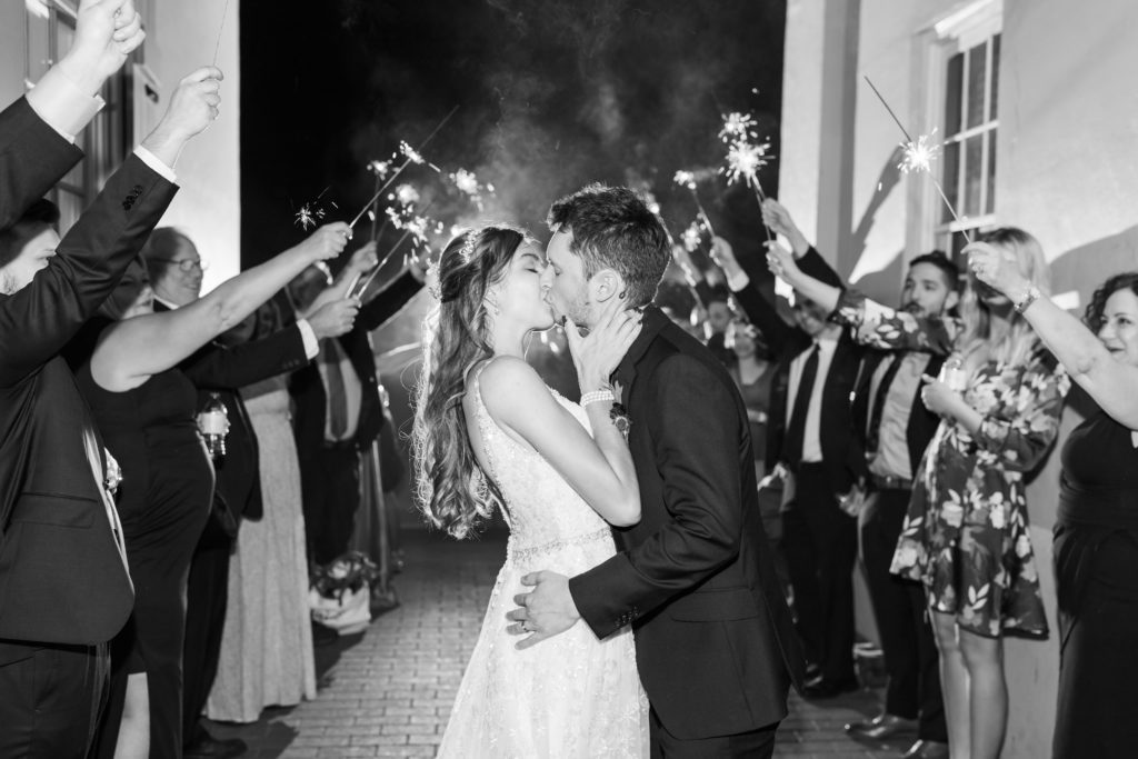 Bride and groom kissing during sparkler exit at the White Room.