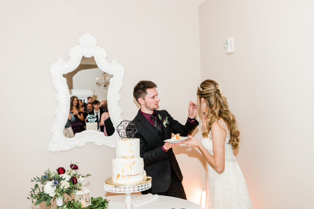 Bride and groom eating cake at their February White Room wedding. 